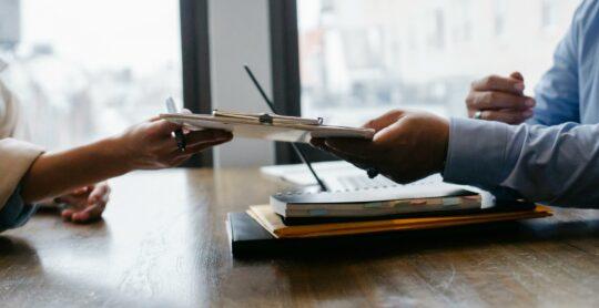 deux mains qui se tendent une fiche de poste